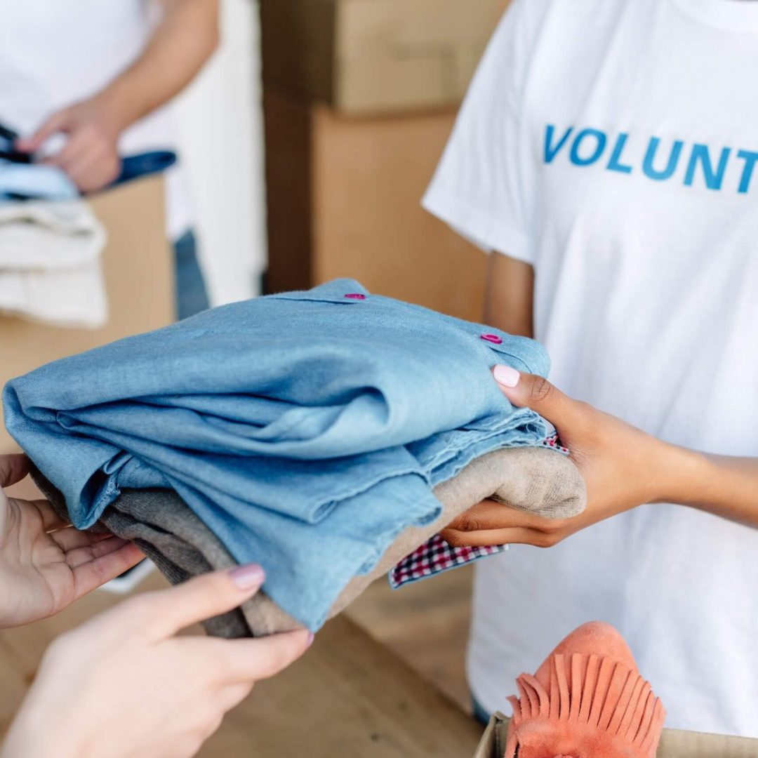 cropped-view-of-volunteer-giving-clothes-to-woman-2022-12-16-21-31-45-utc.jpg